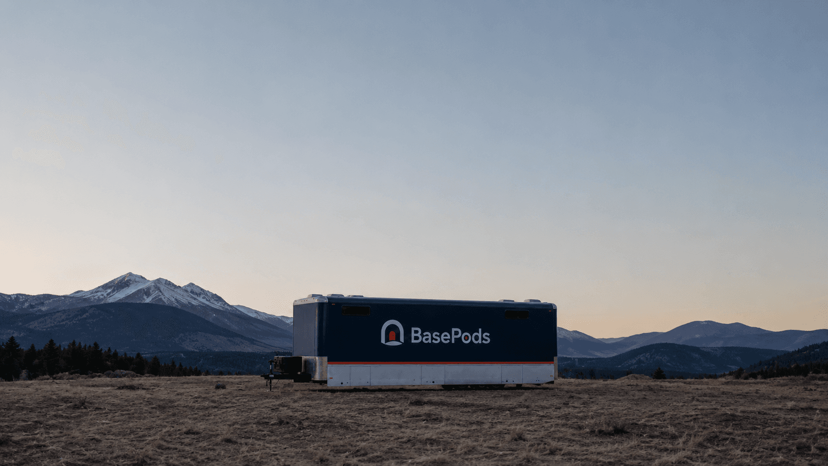 A BasePods trailer in an open natural landscape at dusk